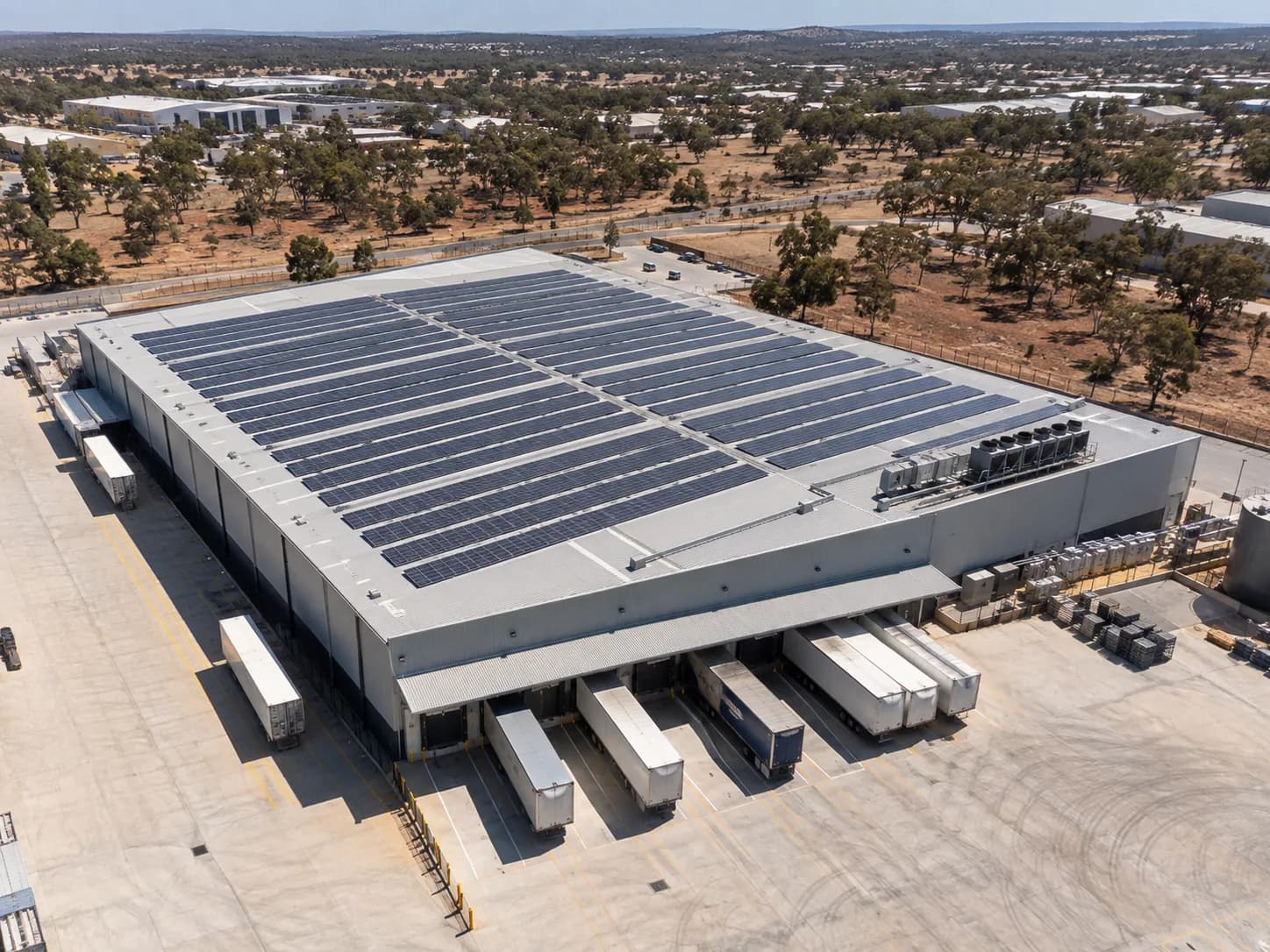 A large flat-roofed distribution warehouse with a rooftop solar array